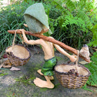 Larger Pixie Carrying Two Baskets on a Tree Branch