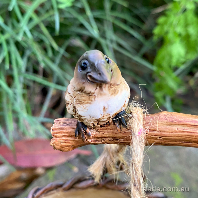 Larger Pixie Carrying Two Baskets on a Tree Branch