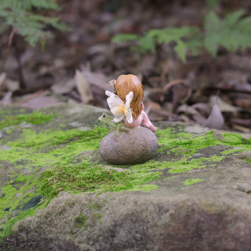 Cute little Fairy Child Sitting on a Rock with her little Frog Friend